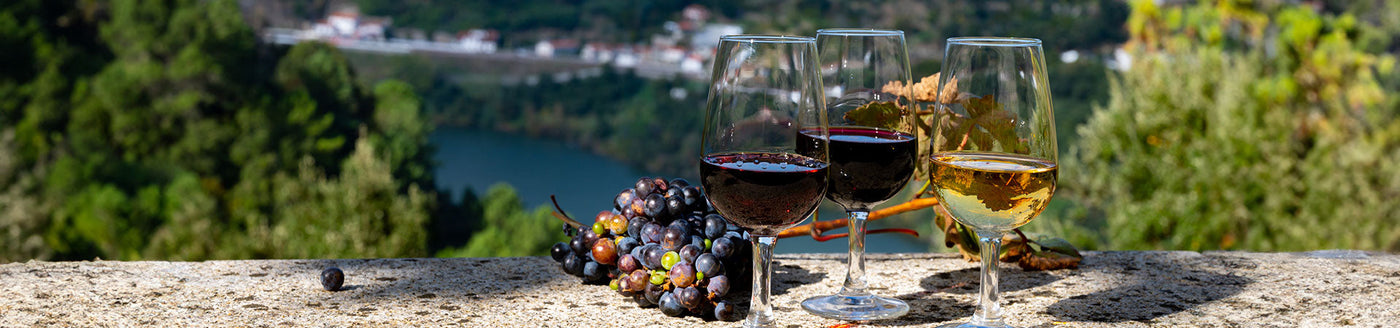 Portwein in Weingläser auf einer Steinmauer vor einem Fluss