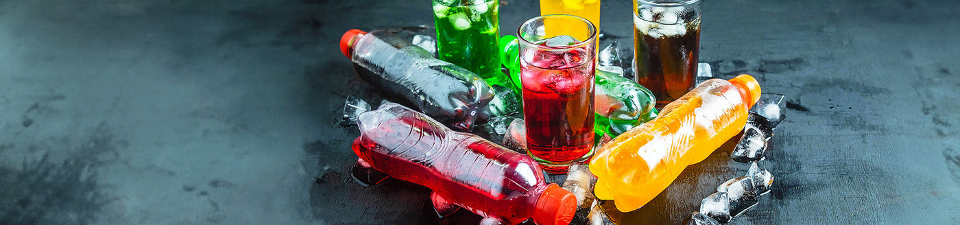 Verschiedene Softdrinks in Gläsern und Flaschen