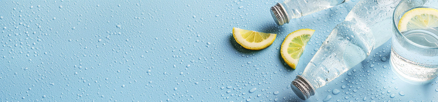 Stiles Mineralwasser ohne Kohlensäure in einer Wasserflasche neben einem Wasserglas