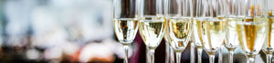 Mehrere mit Sekt gefüllte Sektgläser auf einem Tablett