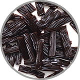 Schwarze Lakritzstücke auf weißem Hintergrund zur visuellen Darstellung der würzig-süßen Aromatik in kräftigen, gereiften Rotweinen