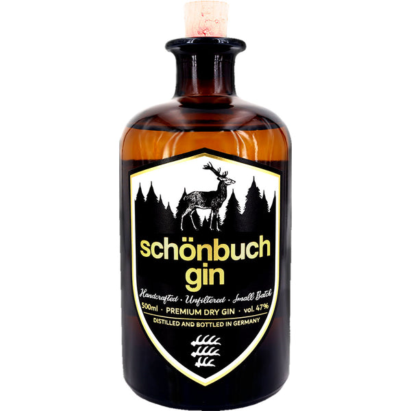 Eine braune 0,5-Liter-Flasche Schönbuch Premium Dry Gin (47%) von Schönbuch Gin, mit einem schwarzen Etikett, das die Silhouette eines Hirsches und eines Waldes zeigt und diesen handgefertigten Dry Gin aus Baden-Württemberg hervorhebt.